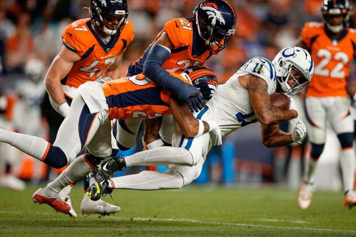 Indianapolis Colts wide receiver Michael Pittman Jr. (11) is tackled by Denver Broncos cornerback Ronald Darby (23) and cornerback K'Waun Williams (21) in the second quarter at Empower Field at Mile High.